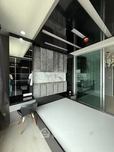 Modern bedroom with sleek design and glass partition, featuring stylish decor and contemporary furniture.