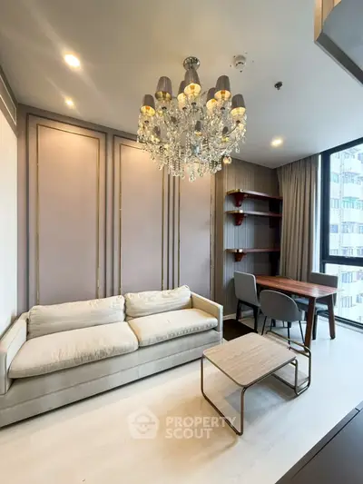 Luxurious living room with elegant chandelier and modern furniture in high-rise apartment.