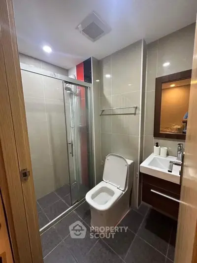 Modern bathroom with sleek shower and contemporary fixtures in a stylish apartment.