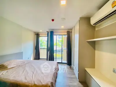 Spacious bedroom with large windows and balcony access, featuring modern design and natural light.