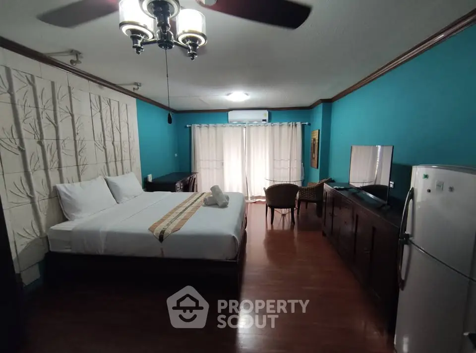Spacious bedroom with elegant decor, featuring a large bed, TV, and seating area, perfect for relaxation.