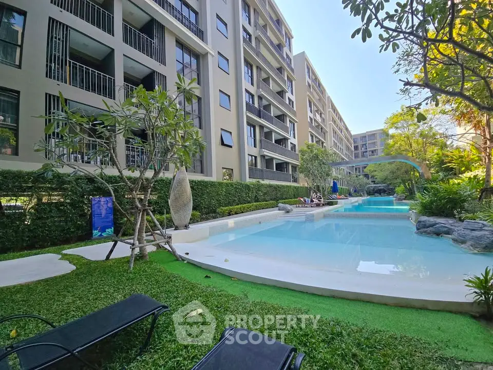 Luxurious apartment complex with serene pool and lush greenery, perfect for relaxation and modern living.