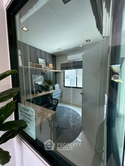 Modern study room with sleek desk and large window, perfect for productivity.