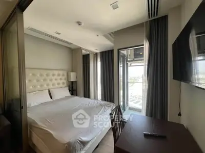 Modern bedroom with balcony access and sleek furnishings in a stylish apartment.