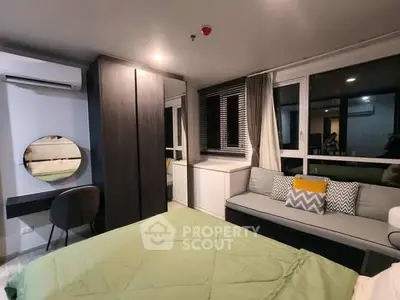 Modern bedroom with stylish decor, large window, and cozy seating area.
