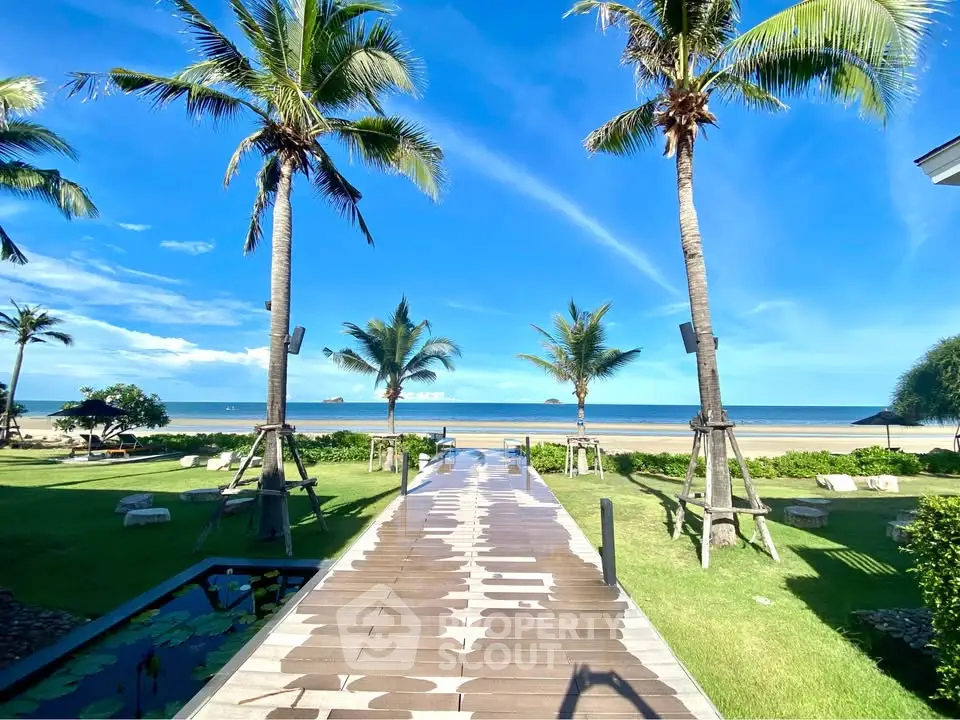 Stunning beachfront view with palm trees and clear blue sky, perfect for a tropical getaway.