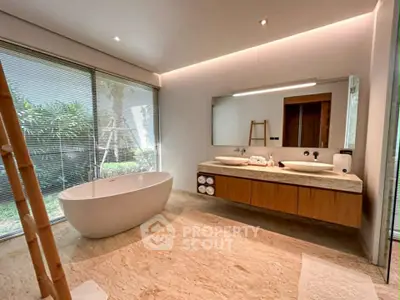 Luxurious modern bathroom with freestanding bathtub and dual sinks, featuring large windows and elegant design.