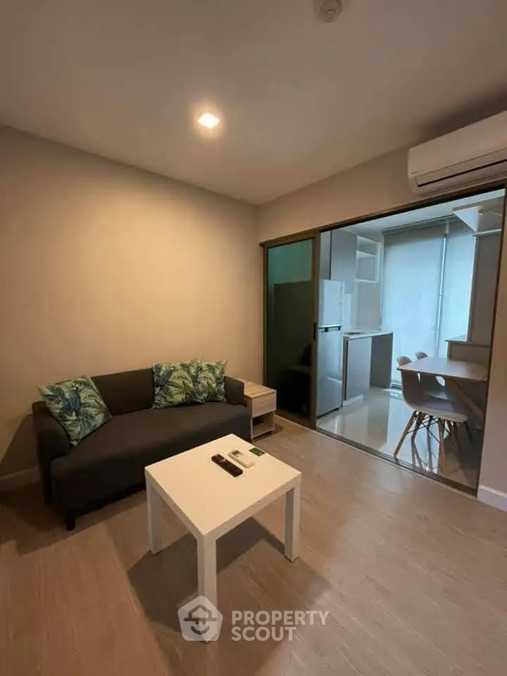 Modern living room with cozy sofa and open kitchen layout in stylish apartment.