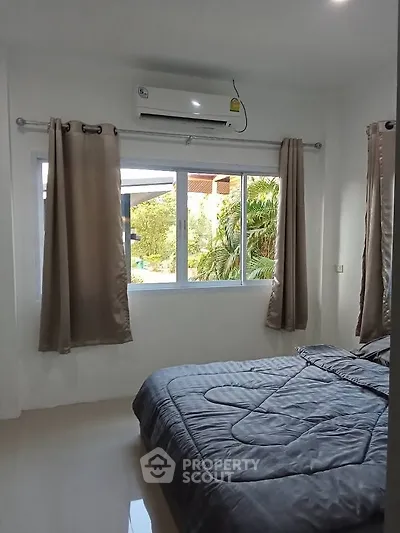 Cozy bedroom with air conditioning and garden view, perfect for relaxation.