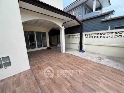 Spacious outdoor patio with wooden flooring and covered area in modern home