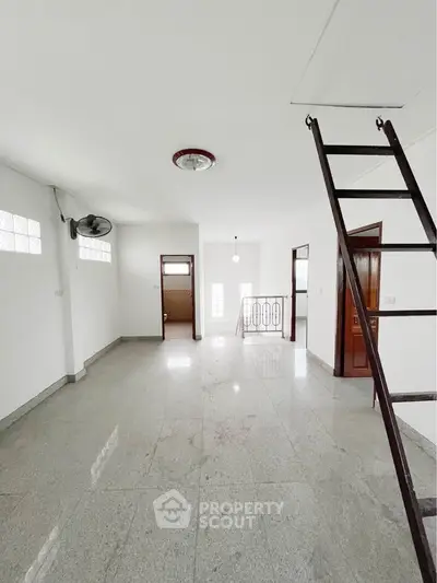 Spacious minimalist interior with ladder access and natural light