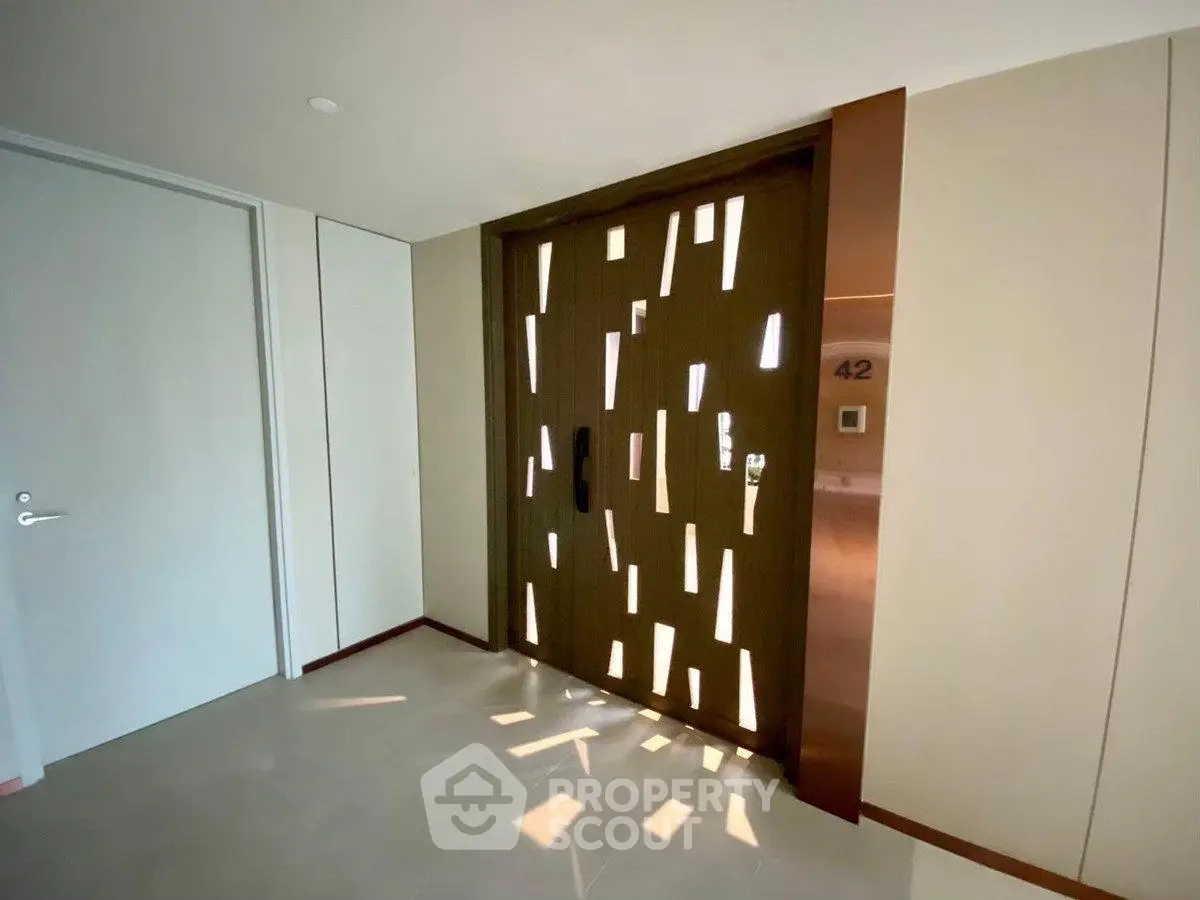 Modern apartment entrance with unique door design and ambient lighting