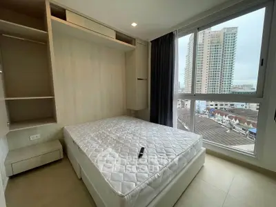 Modern bedroom with large window and city view, featuring built-in storage and sleek design.