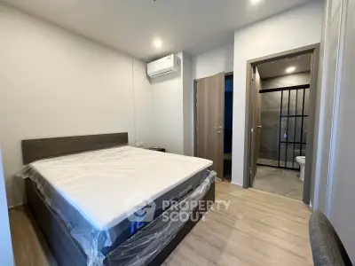 Modern bedroom with ensuite bathroom and air conditioning in a stylish apartment.