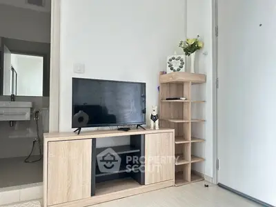 Modern living room with sleek TV stand and open shelving, adjacent to a minimalist bathroom.