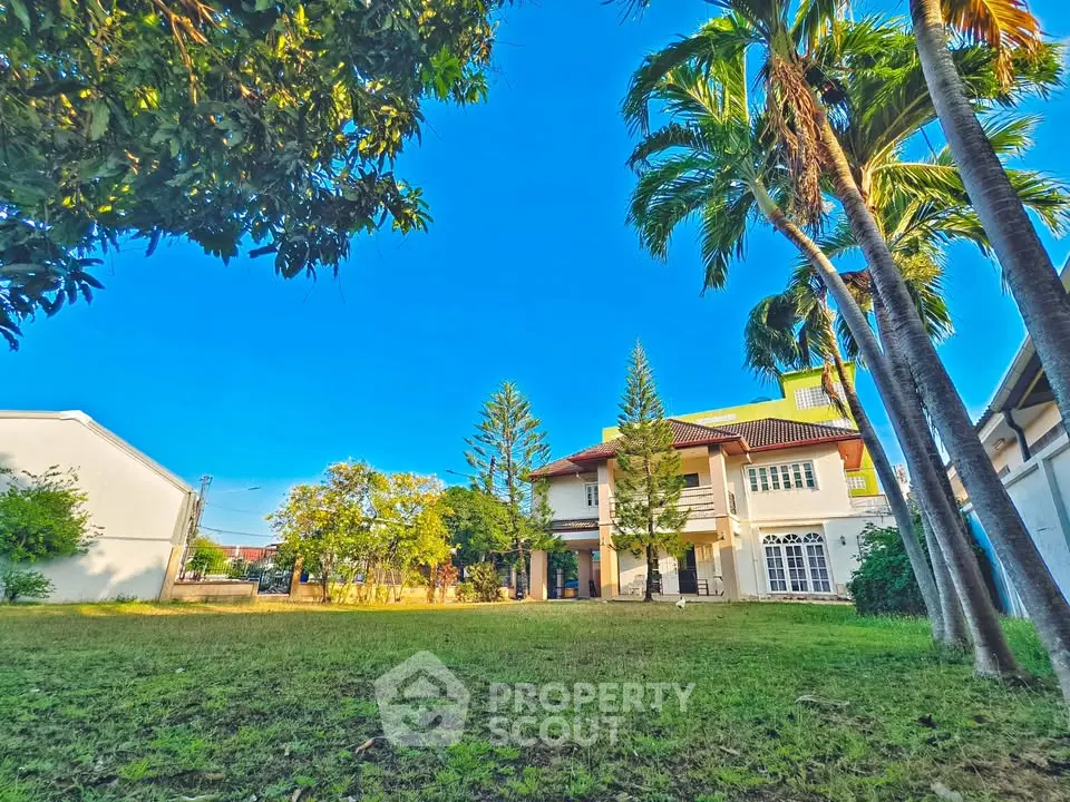 Spacious villa with lush garden and palm trees, perfect for serene living.