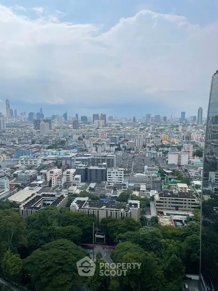 Stunning cityscape view from a high-rise building showcasing urban skyline and lush greenery.