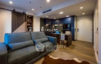 Modern living room with stylish blue sofa and cozy workspace in open layout apartment.