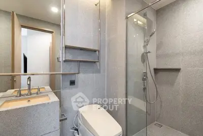 Modern bathroom with sleek design and glass shower enclosure.