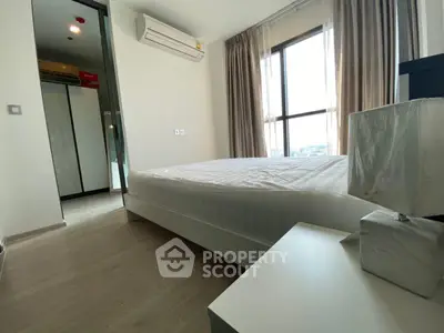 Modern bedroom with large window and air conditioning in a stylish apartment.