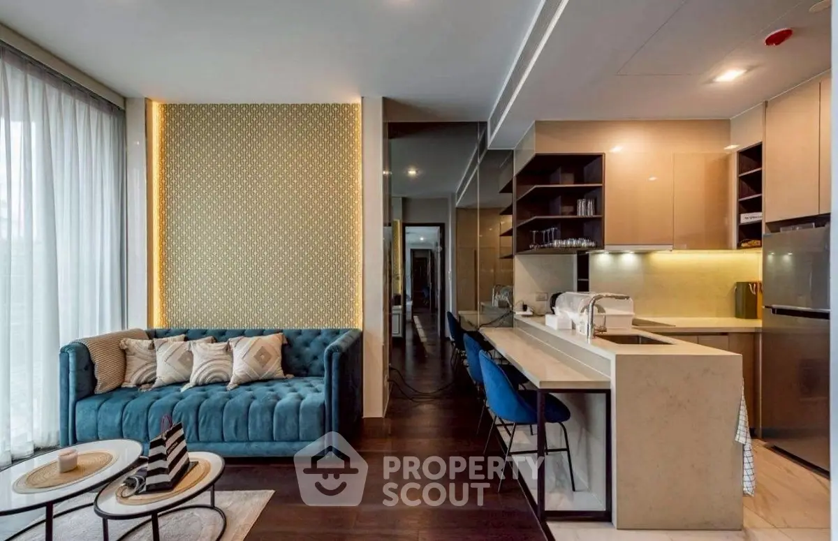 Modern open-layout living room and kitchen with stylish decor and natural light.