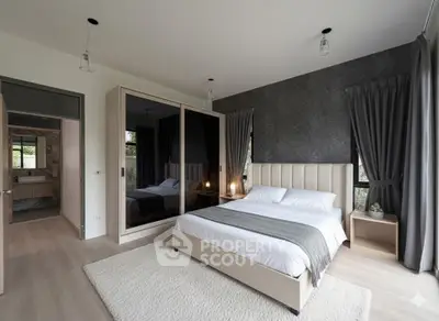 Modern bedroom with stylish decor and large mirrored wardrobe