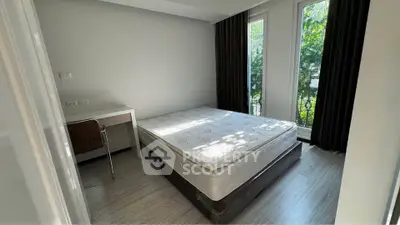 Bright bedroom with large windows and modern furnishings