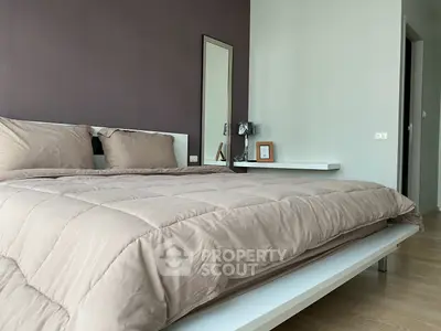 Modern bedroom with stylish decor and cozy bedding in a contemporary apartment.