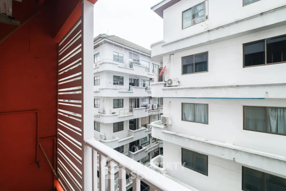 View from balcony overlooking white apartment buildings with modern design.