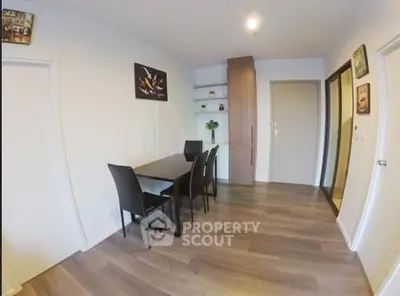 Modern dining area with sleek black chairs and wooden flooring in a stylish apartment.