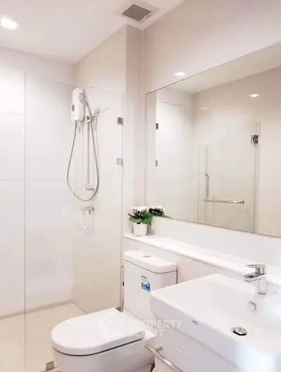 Modern bathroom with glass shower, sleek fixtures, and elegant decor.