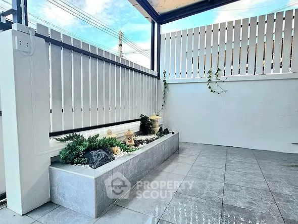 Charming small garden patio with modern tiles and decorative plants, perfect for relaxation.