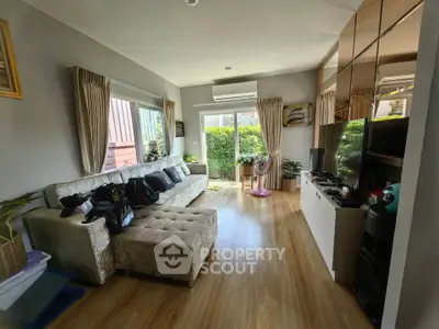 Charming living room with cozy sofa and garden view, perfect for relaxation.