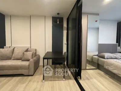 Modern studio apartment with stylish furniture and sleek design, featuring a cozy living area and comfortable bedroom.