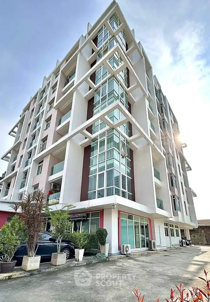 Modern multi-story apartment building with large windows and contemporary design.