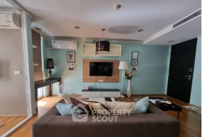 Modern living room with stylish decor, comfortable sofa, and wall-mounted TV in a cozy apartment.