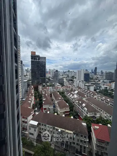 Stunning cityscape view from high-rise building showcasing urban skyline and residential rooftops.