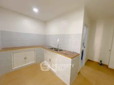 Modern kitchen with sleek countertops and tiled backsplash in a cozy apartment.
