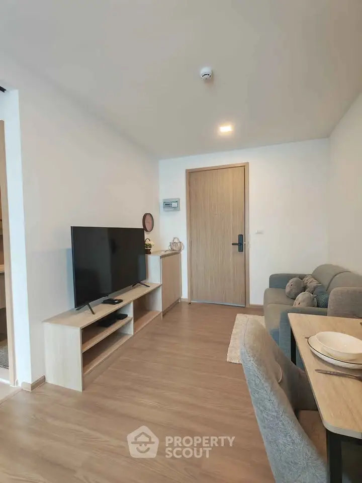 Modern living room with sleek furniture and wooden flooring in a cozy apartment.