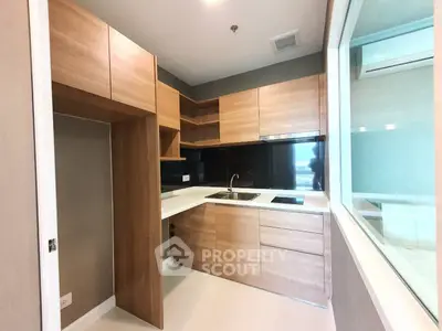 Modern kitchen with sleek wooden cabinets and black backsplash