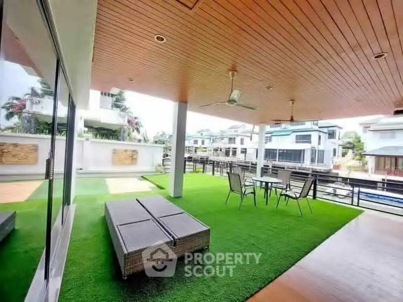 Spacious balcony with artificial grass and outdoor seating in a modern home