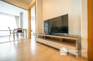 Modern living room with sleek TV stand and wooden flooring, bright and airy ambiance.