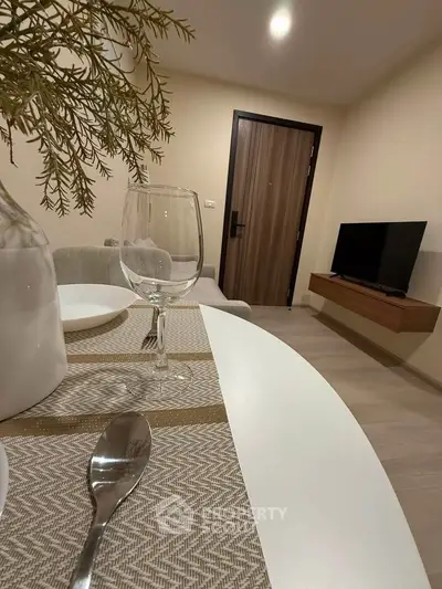 Modern living room with elegant dining setup and flat-screen TV, perfect for cozy gatherings.