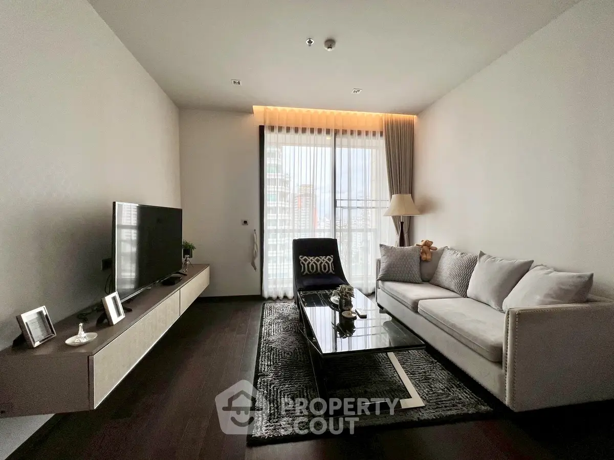 Modern living room with sleek furniture and large window for natural light.