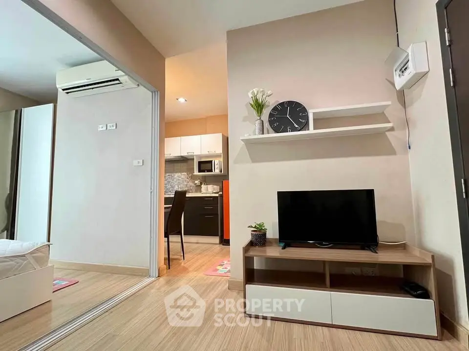 Modern living room with TV and open kitchen in cozy apartment