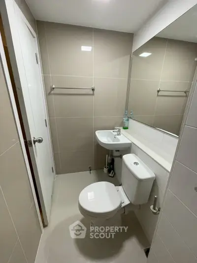 Modern bathroom with sleek fixtures and large mirror, ideal for contemporary living.