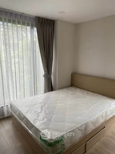 Bright bedroom with large window and new mattress in modern apartment