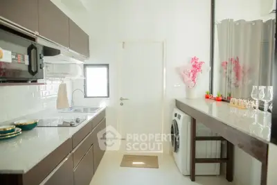 Modern kitchen with sleek cabinets and washing machine, bright and airy design