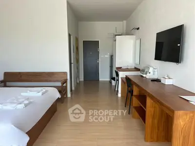 Spacious modern bedroom with wooden furniture and wall-mounted TV