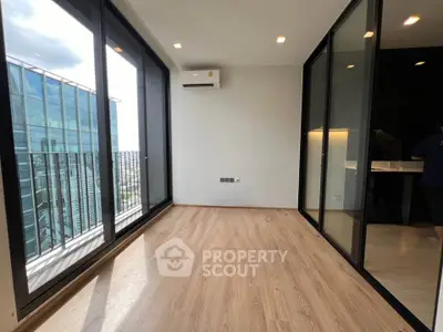 Spacious modern room with large windows and city view, perfect for urban living.